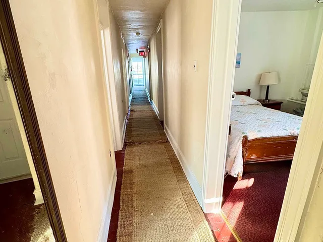 a view of a hallway with wooden floor and stairs