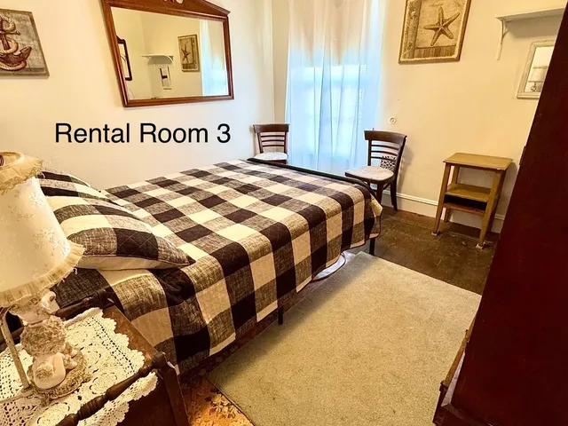 a bed sitting in a bedroom next to a window with pc on the wall