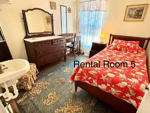 a bed sitting in a bedroom next to a window