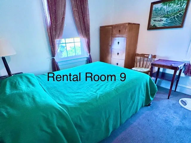 a bed sitting in a bedroom next to a window