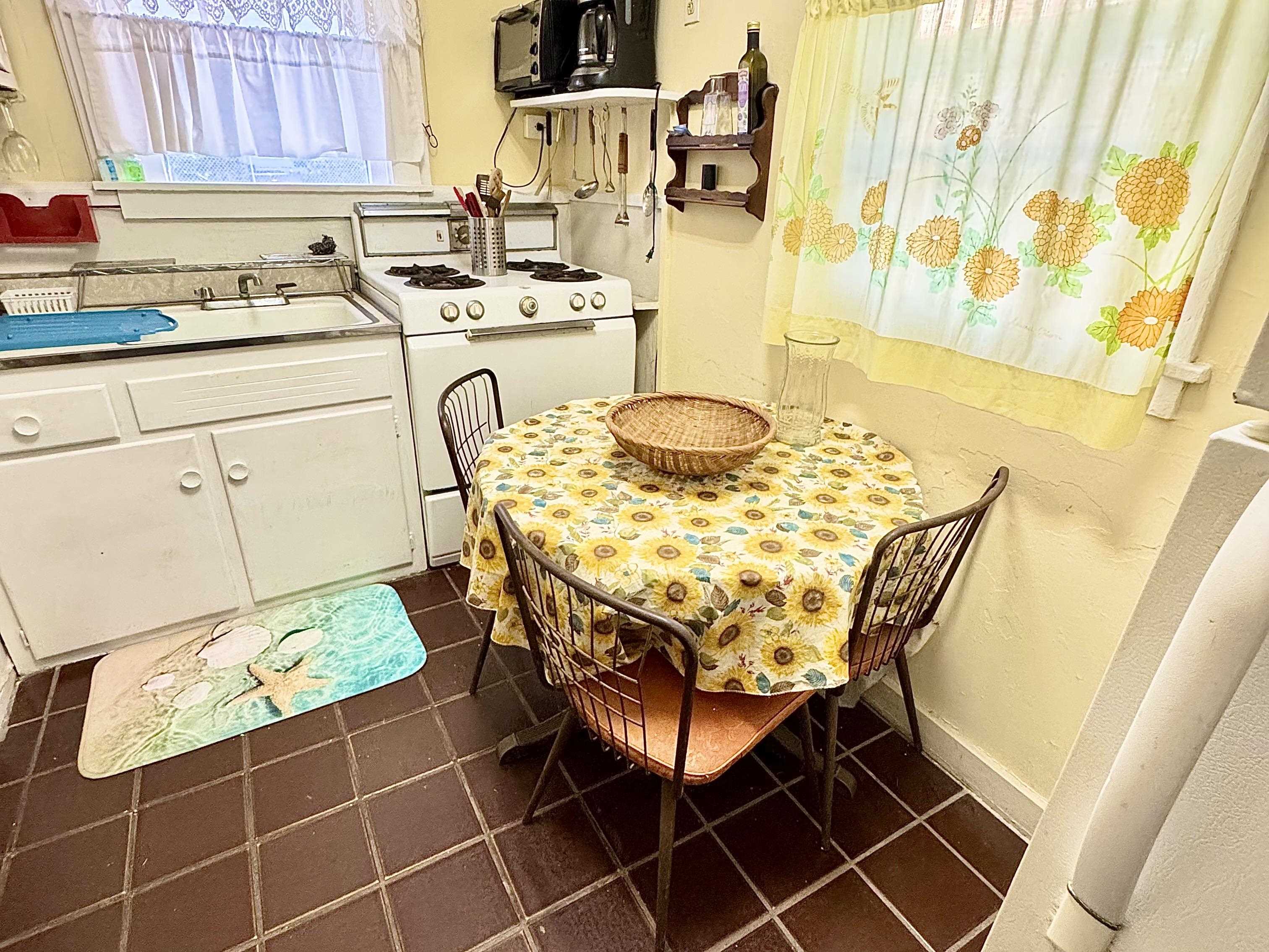 202 Perry Street Cape May, NJ 08204 - Photo 42 of 49 a kitchen with a sink a stove a dining table and chairs