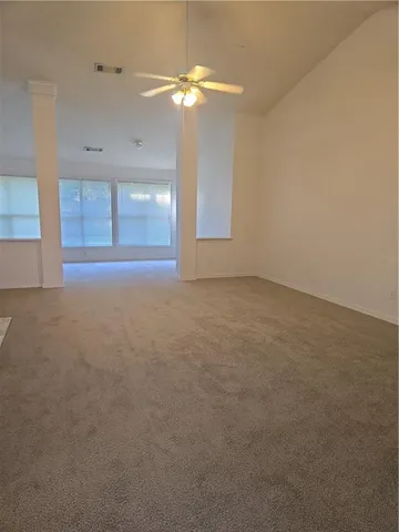 en empty room with windows and fan