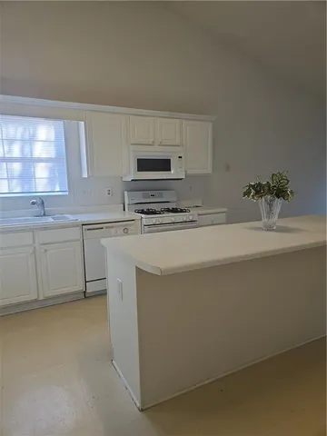 a kitchen with a sink cabinets and a window