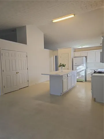 a living room with furniture and kitchen view
