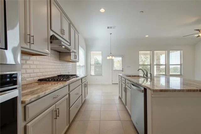 a kitchen with stainless steel appliances granite countertop a stove and a sink