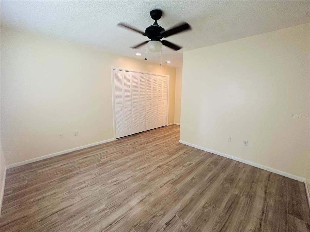 6057 Windhover Drive, Unit E08 Orlando, FL 32819 - Photo 11 of 21 a view of an empty room with wooden floor