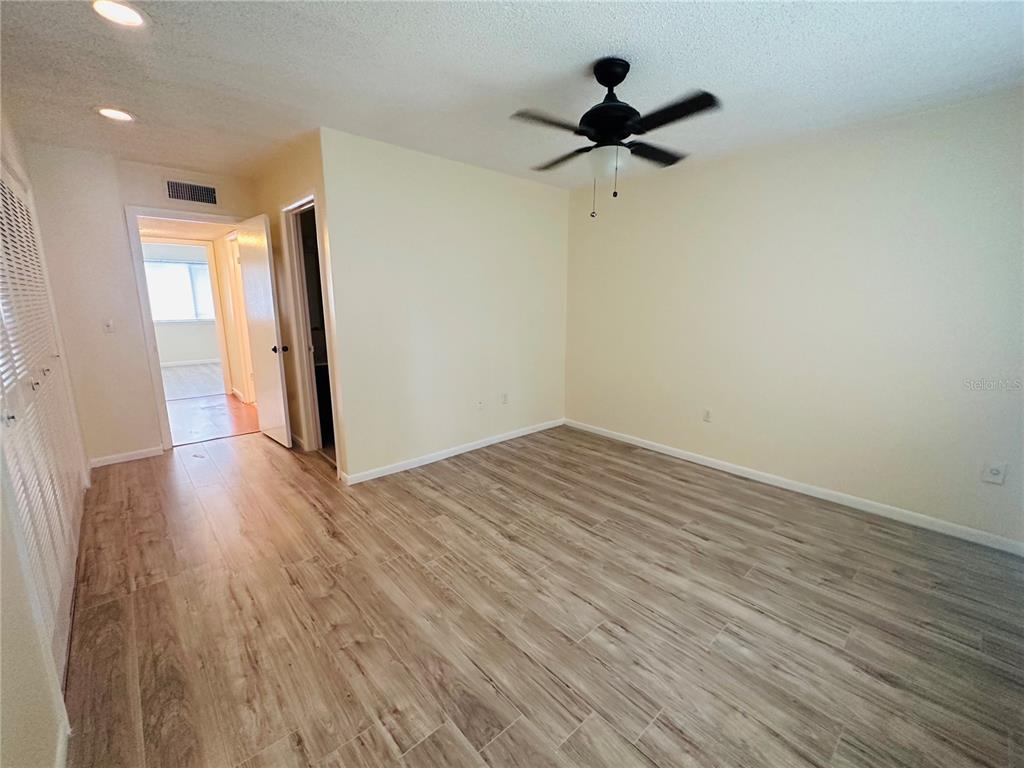 6057 Windhover Drive, Unit E08 Orlando, FL 32819 - Photo 9 of 19 wooden floor in an empty room with a window