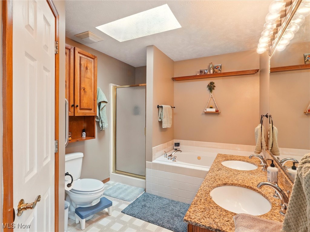 2068 Chimney Ridge Drive Madison, OH 44057 - Photo 20 of 37 Primary full Bathroom featuring a shower stall, a sink, toilet, and a skylight