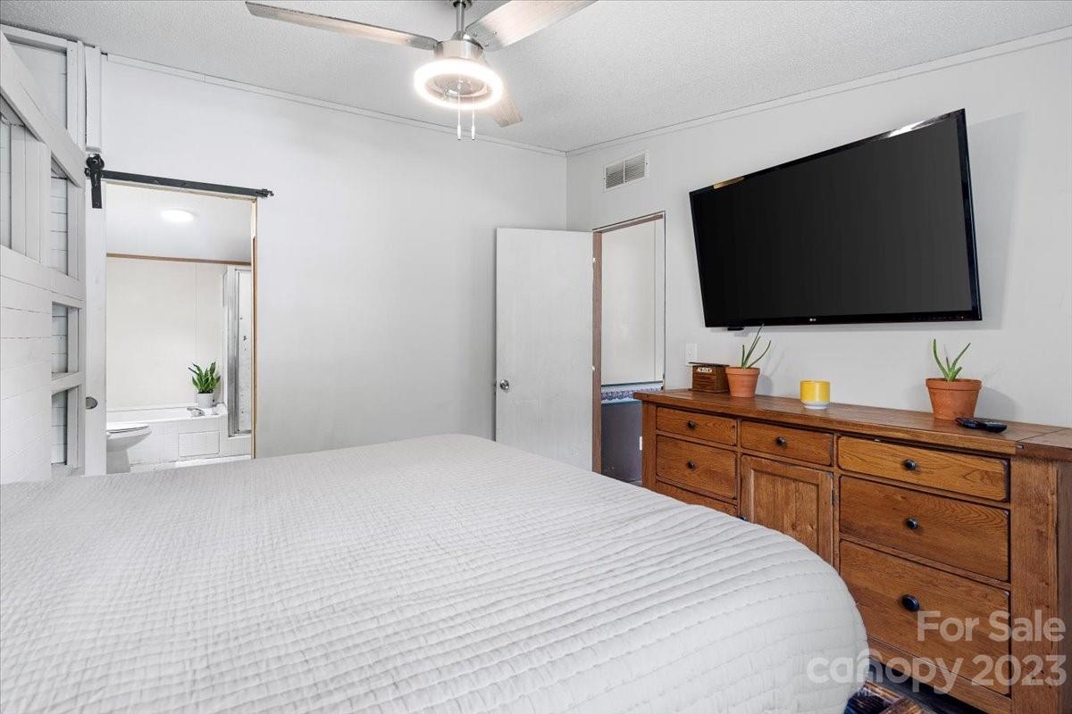 1785 Churchill Road Connelly Springs, NC 28612 - Photo 13 of 27 a bedroom with a large bed and a flat tv screen on dresser
