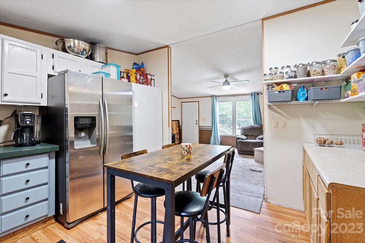 1785 Churchill Road Connelly Springs, NC 28612 - Photo 7 of 27 a kitchen with refrigerator cabinets dining table and chairs