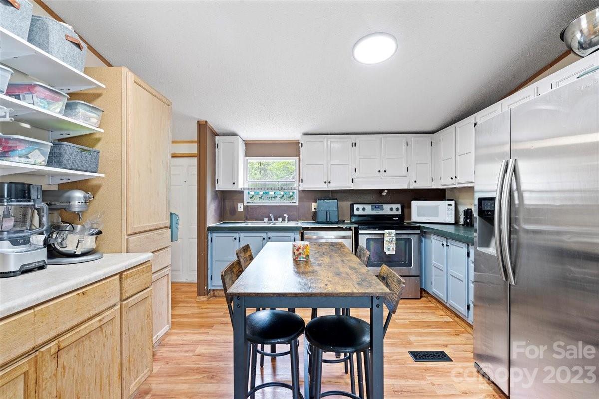 1785 Churchill Road Connelly Springs, NC 28612 - Photo 8 of 27 a kitchen with stainless steel appliances granite countertop a table chairs sink and cabinets
