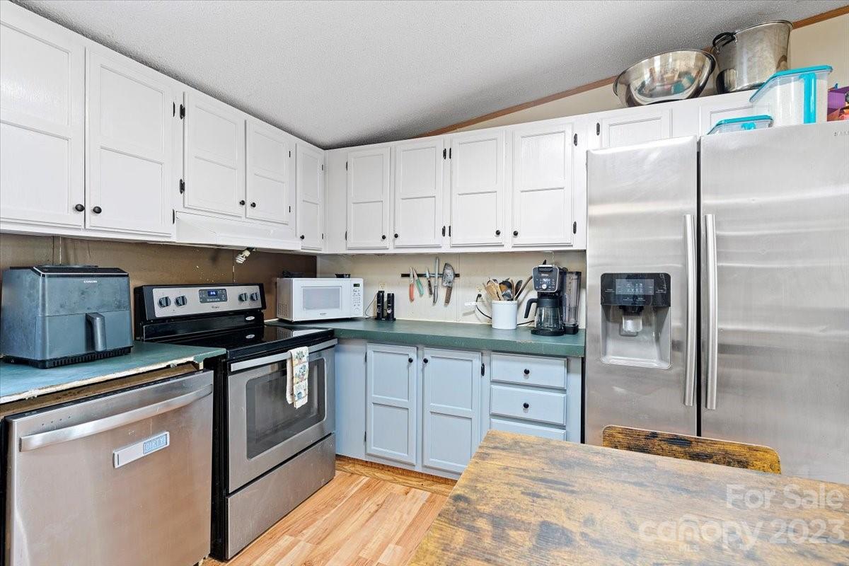 1785 Churchill Road Connelly Springs, NC 28612 - Photo 9 of 27 a kitchen with granite countertop a refrigerator sink and cabinets
