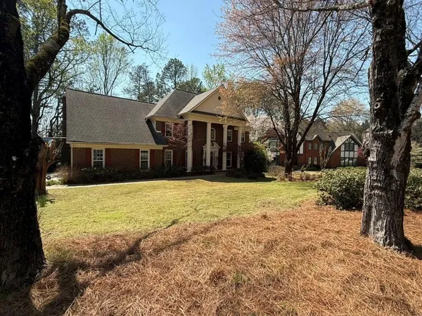 a front view of a house with a yard and trees