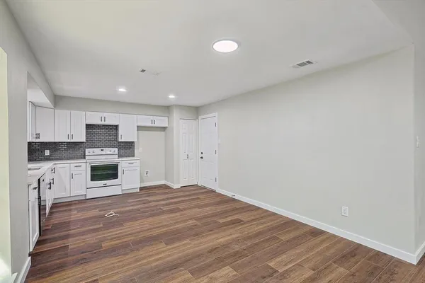 a view of a kitchen with wooden floor and electronic appliances