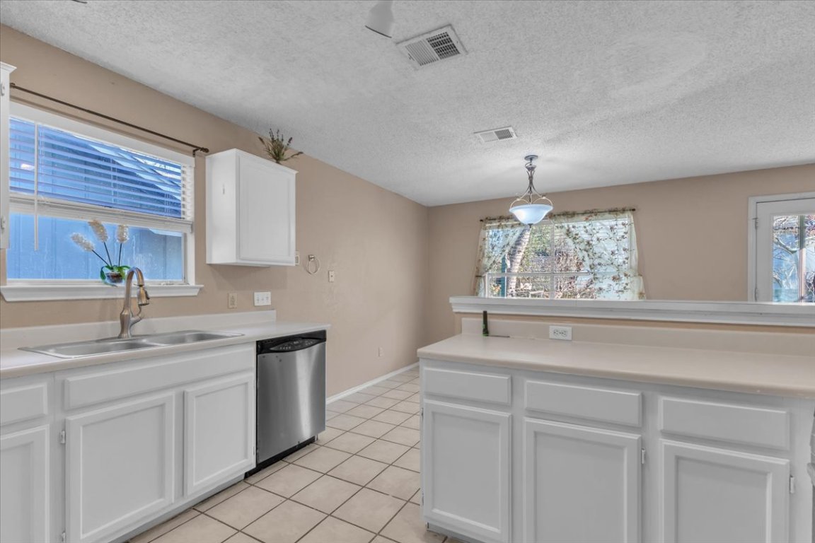 12717 Modena Trail Austin, TX 78729 - Photo 16 of 30 a kitchen with white cabinets and window