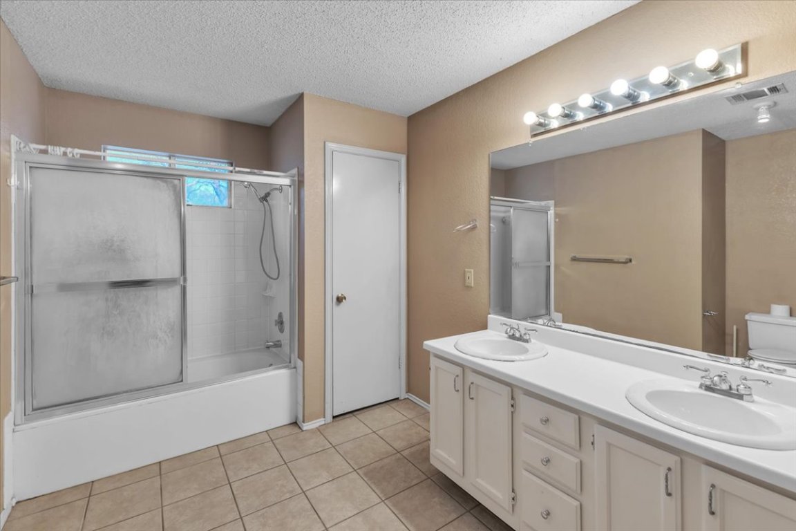 12717 Modena Trail Austin, TX 78729 - Photo 23 of 30 a spacious bathroom with a double vanity sink mirror and shower