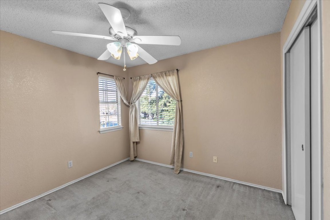 12717 Modena Trail Austin, TX 78729 - Photo 24 of 30 an empty room with a window and a chandelier fan