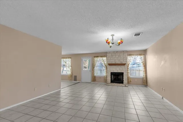 a view of an empty room with window and fireplace