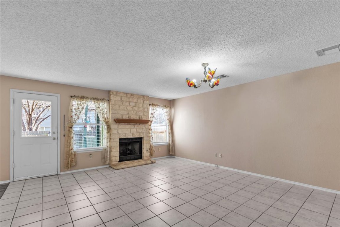 12717 Modena Trail Austin, TX 78729 - Photo 8 of 30 an empty room with windows and fireplace