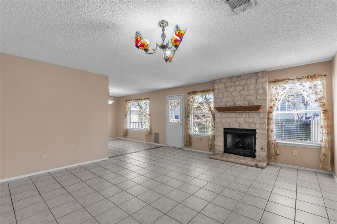 12717 Modena Trail Austin, TX 78729 - Photo 9 of 30 a view of an empty room with a fireplace and a window
