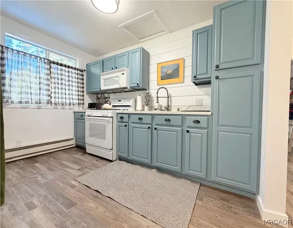 a kitchen with granite countertop a sink stove and refrigerator