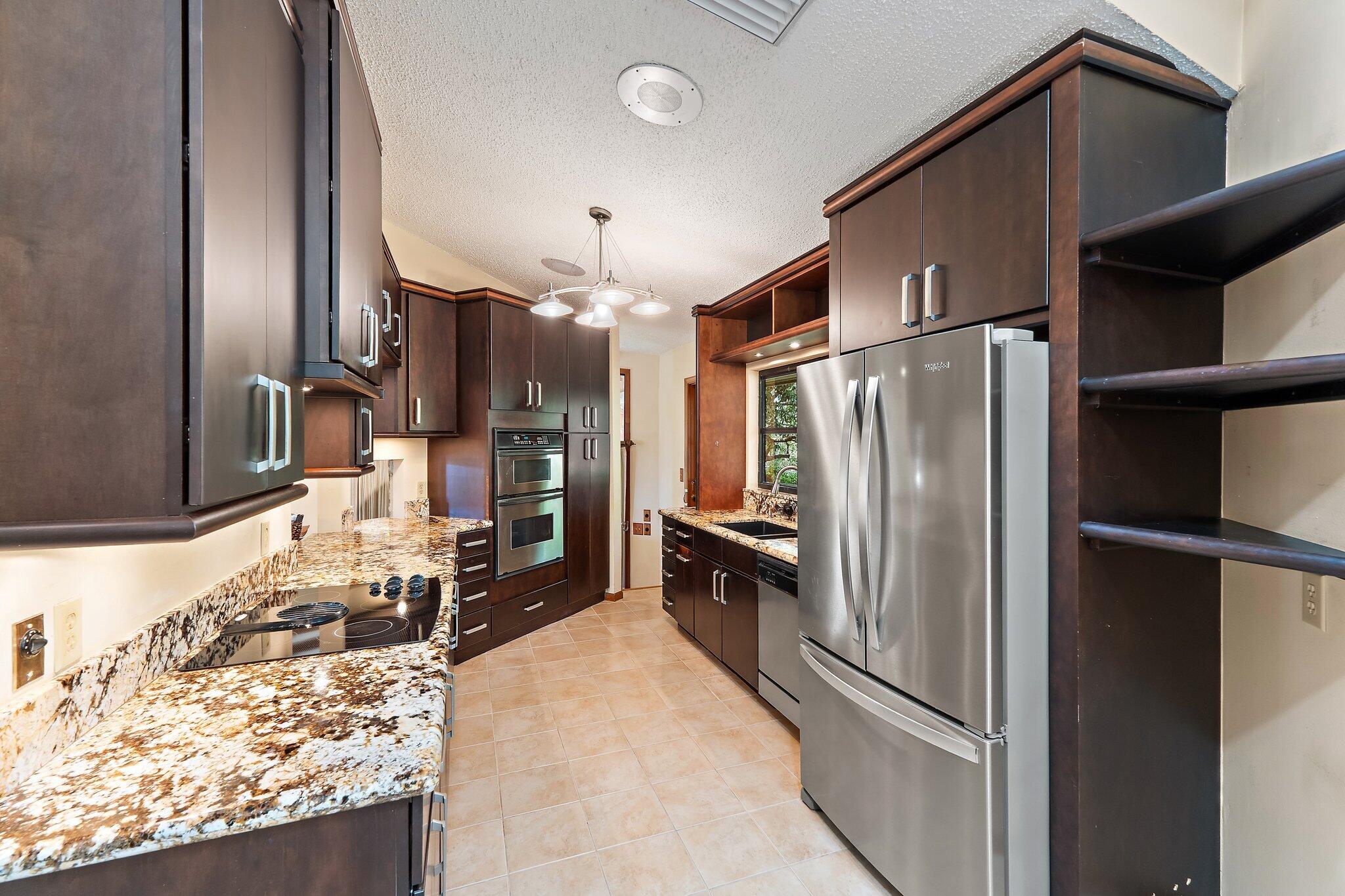 702 Warren Drive Jupiter, FL 33458 - Photo 41 of 76 a kitchen with stainless steel appliances granite countertop a refrigerator and a sink