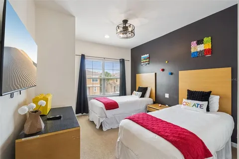 a bedroom with two beds and a chandelier