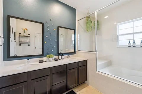 a bathroom with a double vanity sink mirror double and bathtub