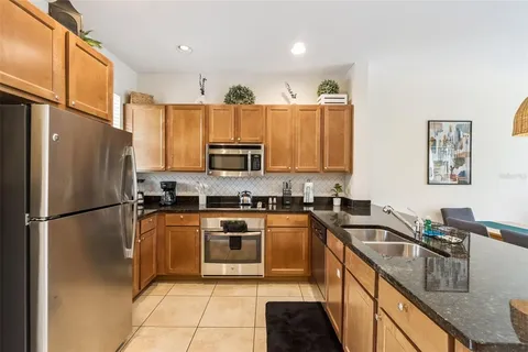 a kitchen with stainless steel appliances granite countertop a refrigerator stove microwave and sink