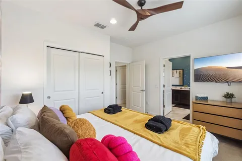 a bedroom with a bed and ceiling fan