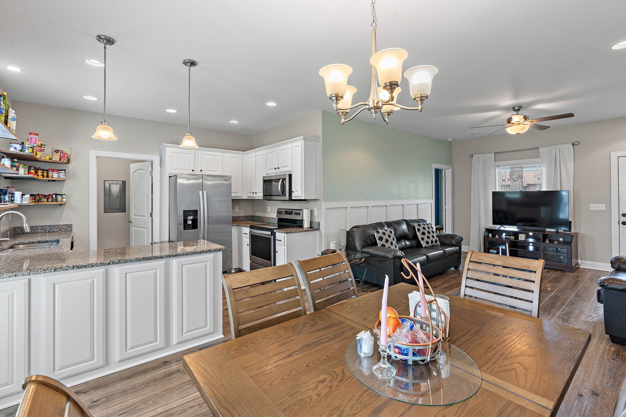 4233 Old Coopertown Road Springfield, TN 37172 - Photo 3 of 28 a kitchen with stainless steel appliances granite countertop a stove refrigerator a dining table and chairs with wooden floor