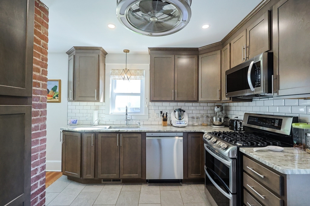 22 Stubb Street, Unit 1 Franklin, MA 02038 - Photo 11 of 42 a kitchen with stainless steel appliances granite countertop a sink stove oven and cabinets