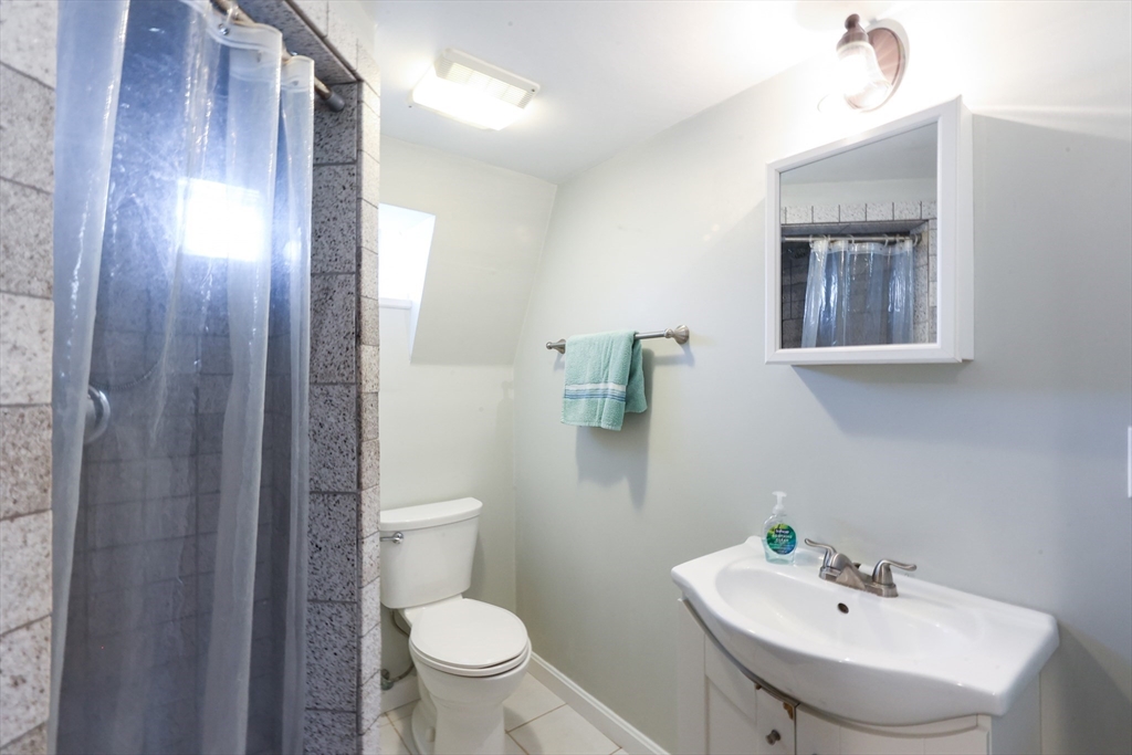 22 Stubb Street, Unit 1 Franklin, MA 02038 - Photo 24 of 42 a bathroom with a toilet a sink and mirror