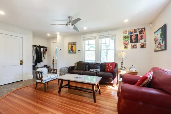 a living room with furniture and a wooden floor