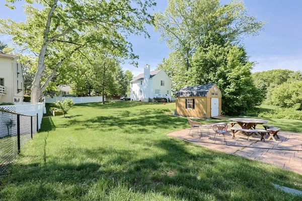 a view of backyard with table and chairs and potted plants