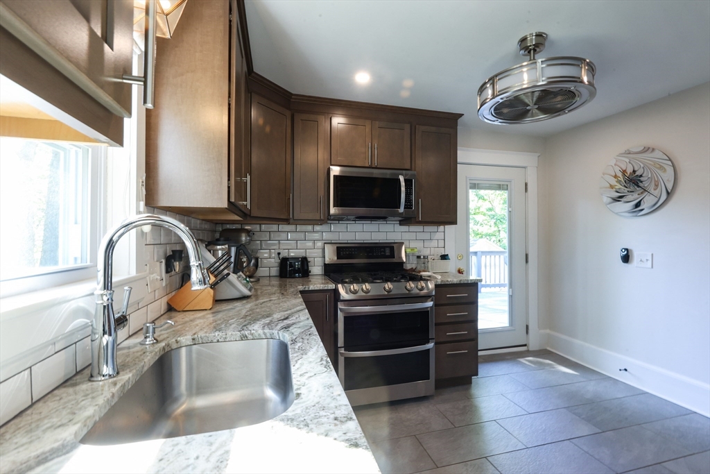 22 Stubb Street, Unit 1 Franklin, MA 02038 - Photo 10 of 42 a kitchen with a sink and a stove top oven with wooden floor