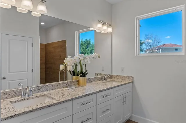 a bathroom with a granite countertop sink and a mirror