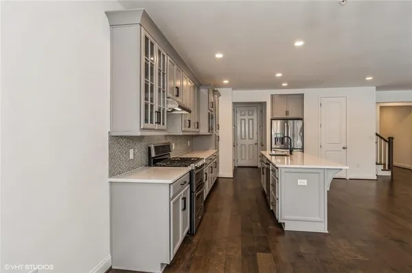 a kitchen with cabinets and wooden floor