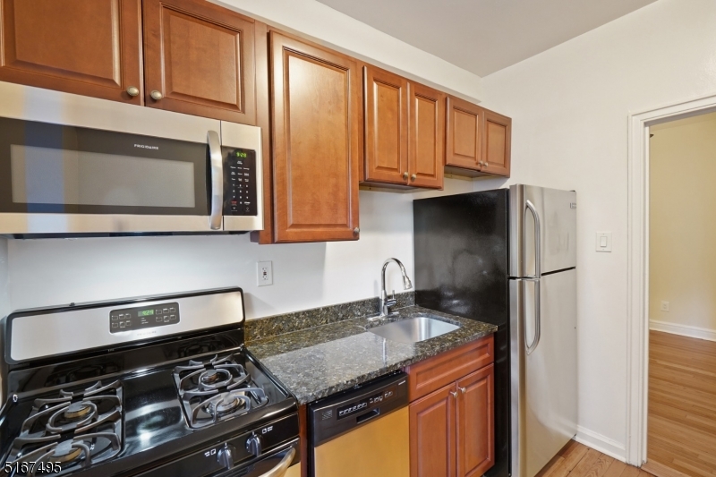 10 North Ridgewood Road, Unit 114 South Orange, NJ 07079 - Photo 2 of 15 a kitchen with stainless steel appliances granite countertop a stove a refrigerator and a microwave