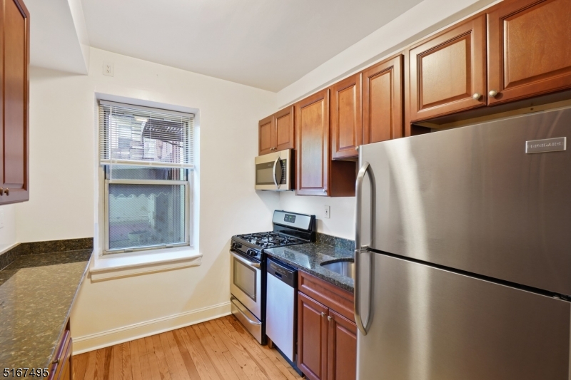 10 North Ridgewood Road, Unit 114 South Orange, NJ 07079 - Photo 3 of 15 a kitchen with stainless steel appliances granite countertop a refrigerator a stove top oven a sink and dishwasher