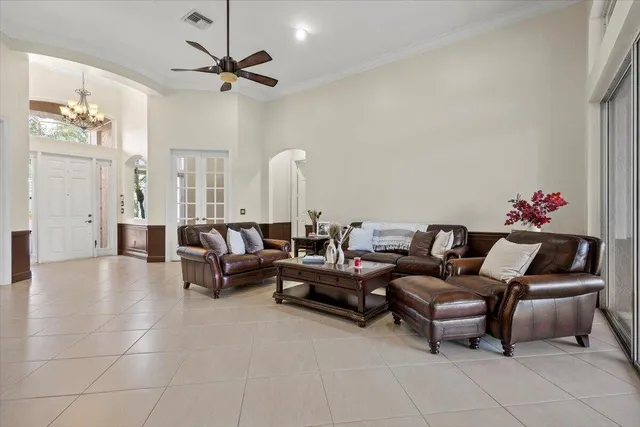 a view of a patio with table and chairs potted plants and floor to ceiling window