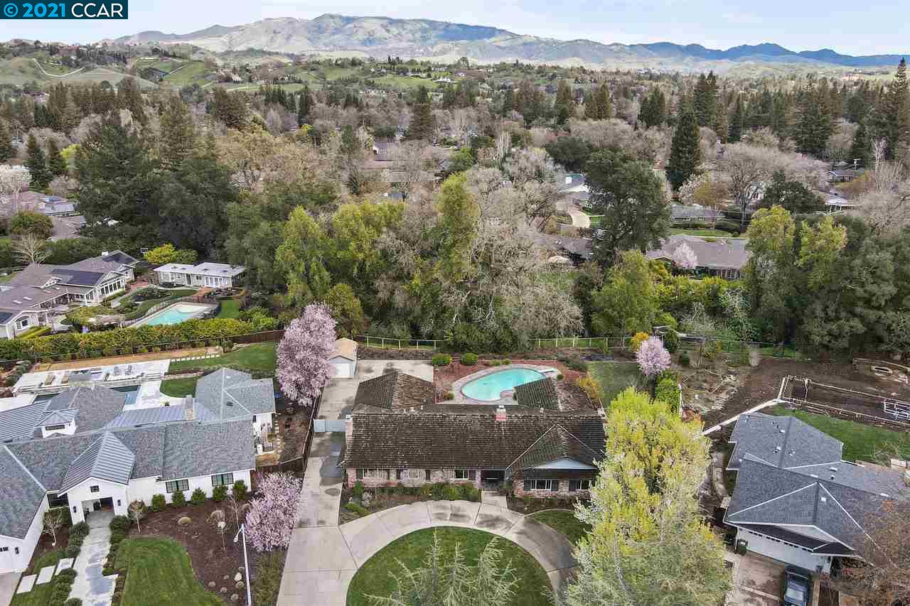 an aerial view of a house with yard swimming pool and mountains