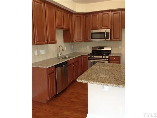 a kitchen with stainless steel appliances granite countertop a stove microwave and sink