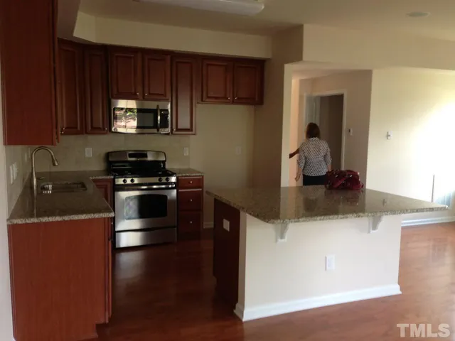 a kitchen with granite countertop a stove and a refrigerator