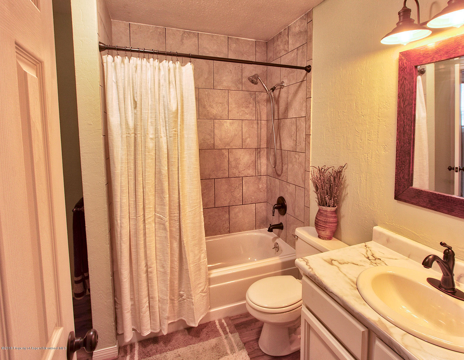 1017 Arnold Court Rifle, CO 81650 - Photo 15 of 28 a bathroom with a sink a toilet and shower curtain