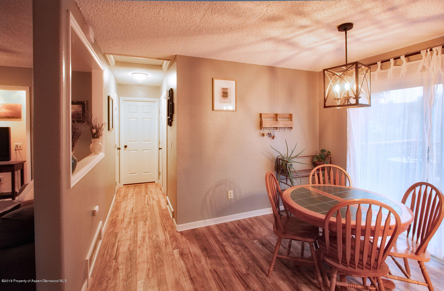 1017 Arnold Court Rifle, CO 81650 - Photo 10 of 28 a view of a hallway to a livingroom with furniture wooden floor and windows
