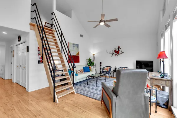 a living room with furniture a chandelier and a dining table