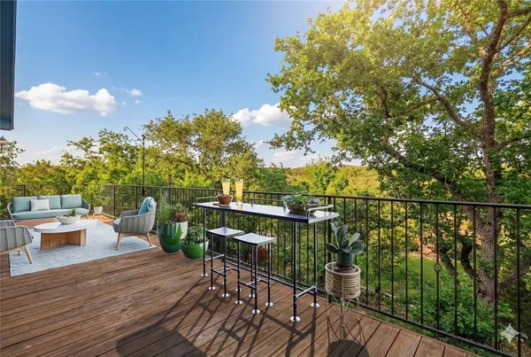 a view of a balcony with chairs and a potted plant