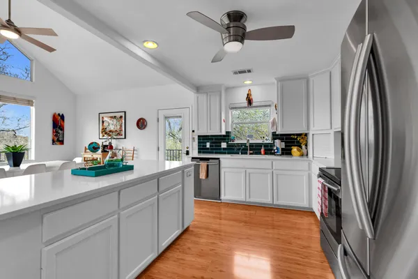 a kitchen with stainless steel appliances cabinets a sink and a potted plant