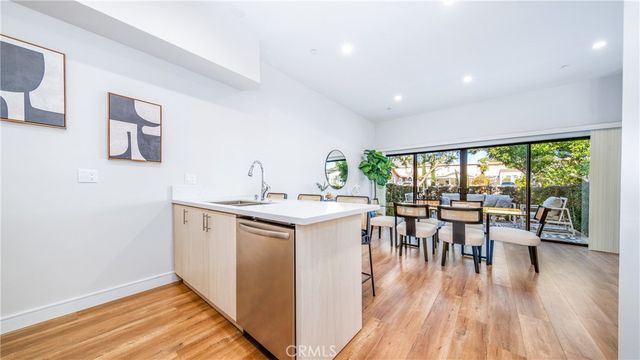 a kitchen with a table chairs stove and wooden floor